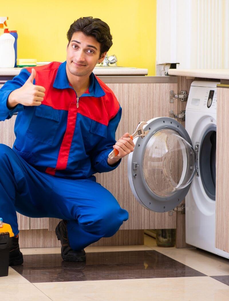 man giving a thumbs up beside a washing machine